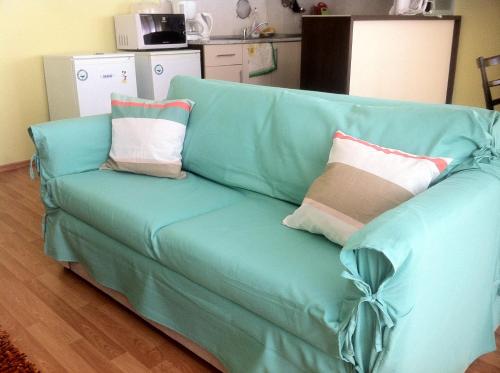 ein blaues Sofa mit Kissen darauf im Wohnzimmer in der Unterkunft Europroperties Iglika Apartments in Goldstrand