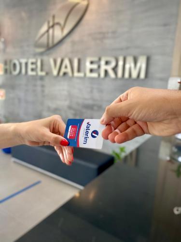a person is holding a box of hotel valentineryn at Hotel Valerim Itajaí / Navegantes in Itajaí