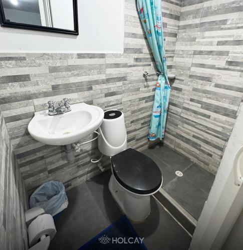a bathroom with a toilet and a sink at Hospedaje Holcay in Bogotá