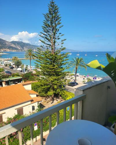 uitzicht op een boom op het strand vanaf een balkon bij Sea Front Madame blue 4-star two-room in ecological health design in Roquebrune-Cap-Martin