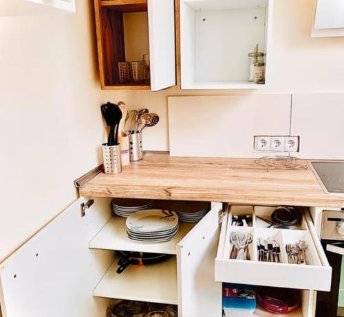 パーダーボルンにある3 Ferienwohnungen in stadt Paderbornの白いキャビネットと木製のカウンタートップを備えたキッチン