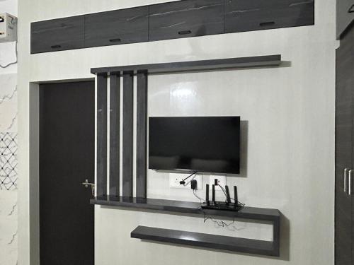 a flat screen tv on a wall in a room at Rumi HomeStays-104-1BHK in Bhubaneshwar