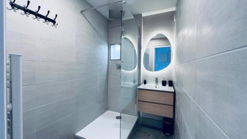 a white bathroom with a sink and a mirror at Studio cosy proche de Paris in Drancy