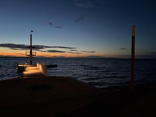 a dock with a bench on the water at sunset at Seeschwalbe 78 Kompassweg in Rechlin