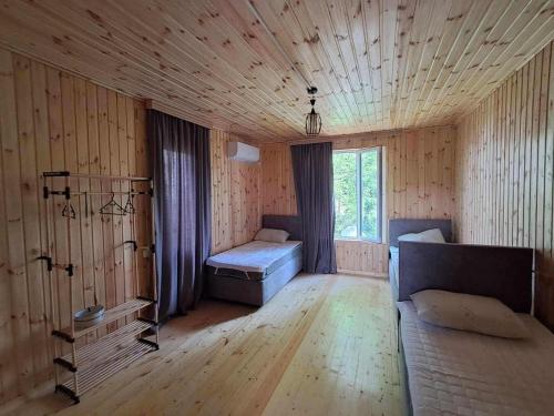 a room with a bed and a couch and a window at Villa Lematue in Jvari