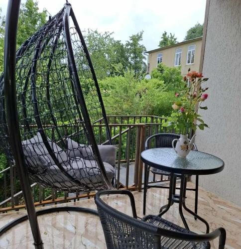 a hammock on a patio with a table and chairs at Villa Lematue in Jvari