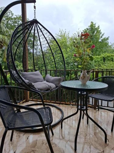 a patio with two chairs and a table and a swing at Villa Lematue in Jvari