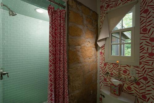 a bathroom with a red shower curtain and a window at Brisbane House in Arena