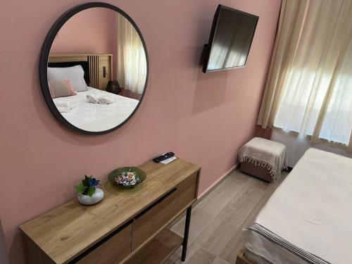 a bedroom with a mirror on a pink wall at Cleos House in Trýgonas