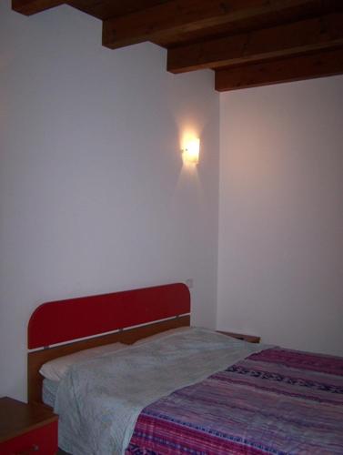 sypialnia z łóżkiem i lampką na ścianie w obiekcie b&b da Maria w mieście Fagagna