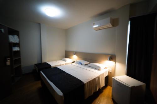 a hotel room with two beds and a television at Hotel Valerim Itajaí / Navegantes in Itajaí