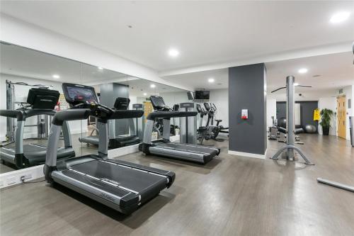 a gym with treadmills and elliptical machines at Canary Wharf-WOMEN Only-Private Double Room & Pool Gym in London