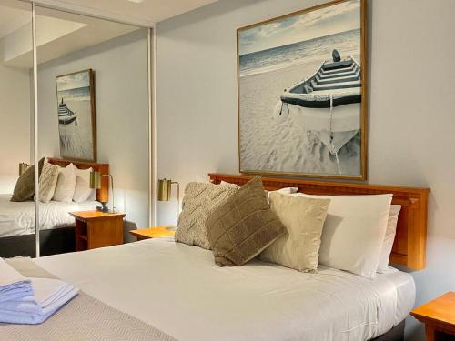 a bedroom with a bed and a picture of a boat at 6 Executive Eastside Parking & Pool in Perth