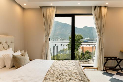 a bedroom with a bed and a large window at Adiya Signature Hotel - Adults only in Kotor