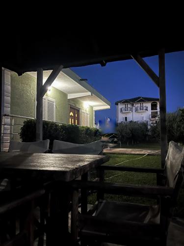 a table and chairs in front of a house at night at OLIVE Home in Durrës