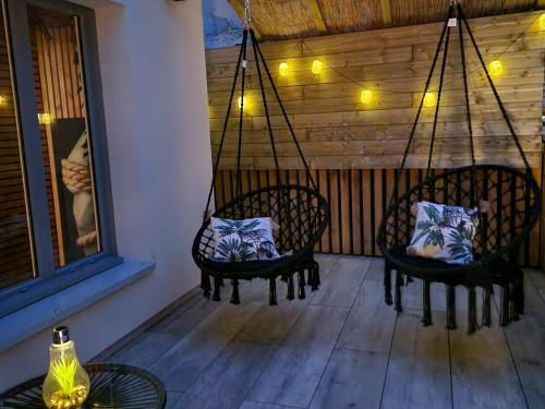 two chairs with pillows on them on a porch at Love Room Tentation in Ornans