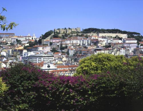 a view of a city with a castle on a hill at Parque de Campismo Orbitur Costa de Caparica in Costa da Caparica