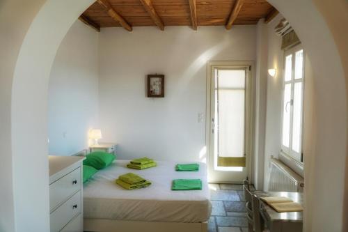 a white bedroom with a bed and a window at Bella Vista in Naousa