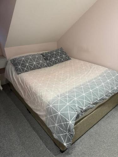 a small bed in a corner of a room at Henlow 2 Bedroom Annexe in Henlow