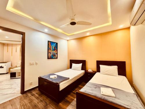 a hotel room with two beds and a mirror at 2 Bedroom Cozy Apartment by Lux Haven Stays in Lahore
