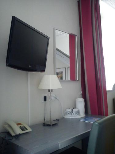 TV a/nebo společenská místnost v ubytování Hôtel Carmin