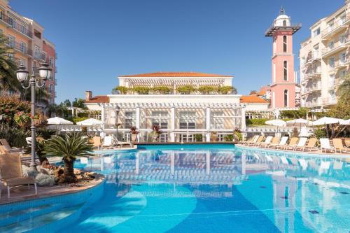 a swimming pool in front of a building with a clock tower at IL Campanário Villaggio Resort Suítes - Jurerê Internacional - Reserva direta com dono in Florianópolis
