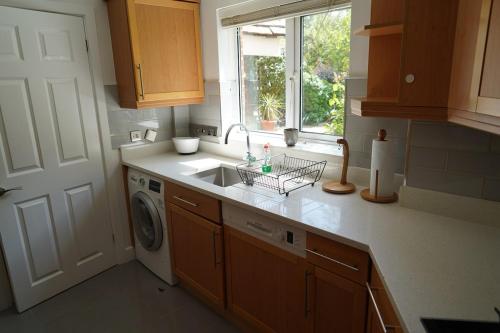 a kitchen with a sink and a washing machine at Central Woking in Horsell