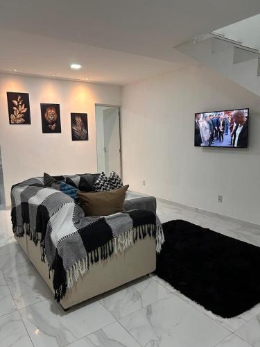 a bedroom with a bed and a wall with pictures at Casa com piscina em Jauá in Camaçari