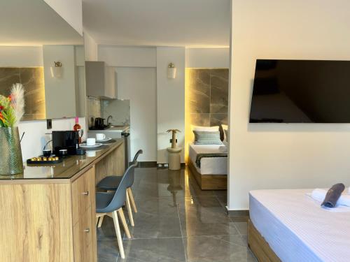 a hotel room with a kitchen and a bedroom at Celine Luxury Suites and Rooms in Olympiaki Akti