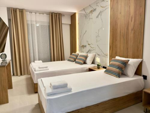 a hotel room with two beds and a map on the wall at Celine Luxury Suites and Rooms in Olympiaki Akti