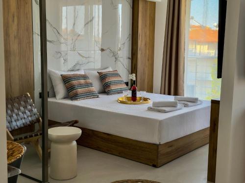 a bedroom with a bed with a plate on it at Celine Luxury Suites and Rooms in Olympiaki Akti