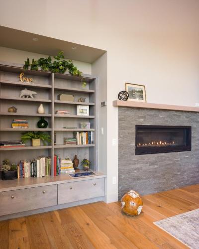 a living room with a fireplace and a book shelf at Luxury Waterfront & Views, Private Beach, Golfing in Eastsound