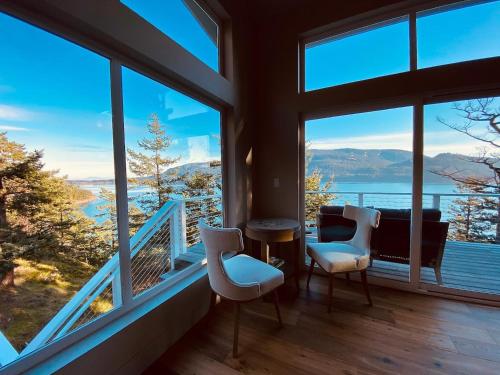 a room with windows with a view of the water at Luxury Waterfront & Views, Private Beach, Golfing in Eastsound