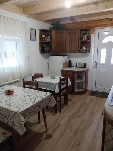 a kitchen with two tables and a refrigerator at Rent a rooms - "Laki" in Žabljak