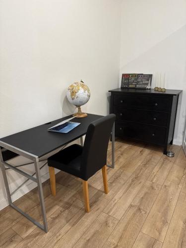 a desk with a chair and a table with a globe on it at Central Terrace Apartment in Nové Zámky