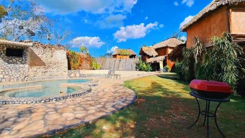 a backyard with a pool and a bar stool at Cabañas Aldea Yalcón in Valladolid