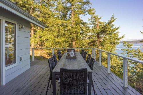 a wooden deck with a wooden table and chairs at Luxury Waterfront & Views, Private Beach, Golfing in Eastsound