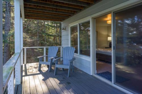 two blue chairs sitting on the porch of a house at Luxury Waterfront & Views, Private Beach, Golfing in Eastsound