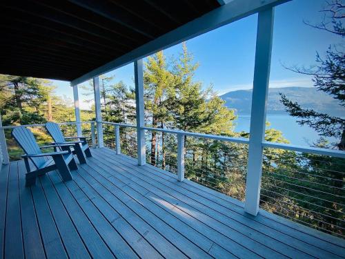 a porch with two chairs and a view of the water at Luxury Waterfront & Views, Private Beach, Golfing in Eastsound