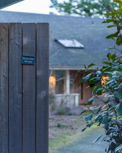 a sign on a wooden fence in front of a house at Luxury Waterfront & Views, Private Beach, Golfing in Eastsound