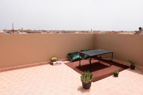 a table on a balcony with a view of a city at KECHDAYS, Apartment near airport in Marrakech