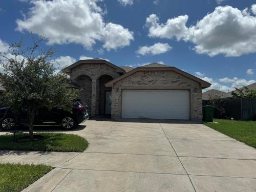 a car parked in front of a house with a garage at Charming 3-Bedroom Retreat in Prime Neighborhood in Brownsville