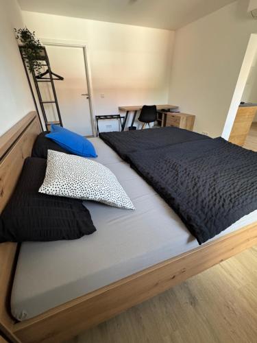 a large bed with black sheets and pillows on it at Ferienwohnung Wasser - Bude in Momlingen