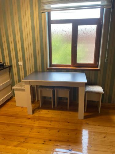 a table and a chair in a room with a window at Əşlə günlük ev in Lankaran