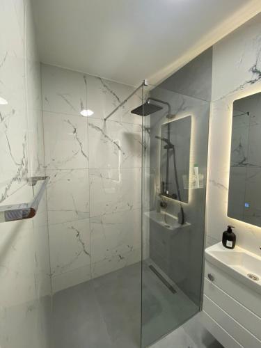 a bathroom with a glass shower and a sink at Studio8 centerapartment Prizren in Prizren