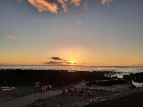 a group of people standing on the beach at sunset at Casa vicente in Santa Cruz das Flores