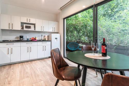 a kitchen with a table with a bottle of wine at Insurgentes APT Private Balcony, Roof Lounge in Mexico City