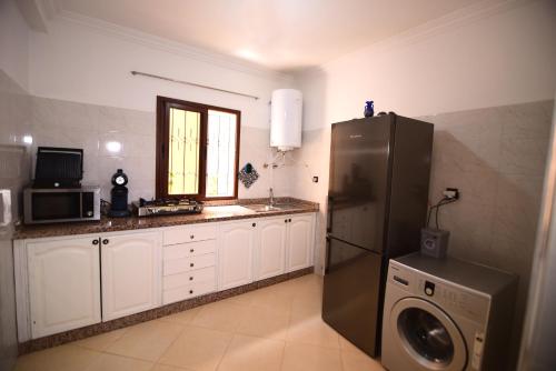a kitchen with a refrigerator and a washer and dryer at KECHDAYS, Apartment near airport in Marrakech