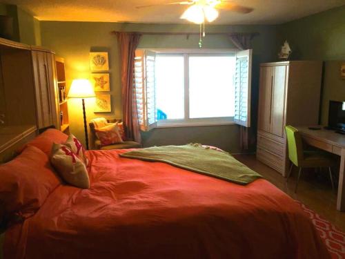 a bedroom with a large red bed with a window at Serene 2br Oceanfront Condo With Balcony, Florida in Ponce Inlet