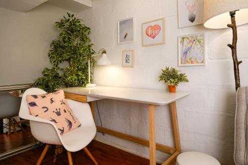 a desk and two chairs in a room with plants at Charming Basement Suite with Private Entrance Near Subway, Koreatown & UofT in Toronto